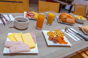 a table topped with plates of food and drinks at SOWELL RESIDENCES New Chastillon in Isola 2000