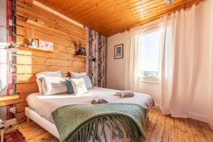 - une chambre avec un lit et un mur en bois dans l'établissement La Maison Perchée, à Thiers
