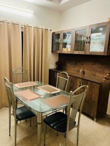 維沙卡帕特南的住宿－Vyasams Happy Nest，一间设有玻璃桌和椅子的用餐室