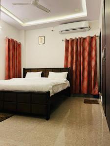 維沙卡帕特南的住宿－Vyasams Happy Nest，一间卧室配有红色窗帘的床