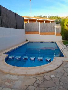 uma piscina com quatro mesas de piquenique em Quevoy em Alcañiz