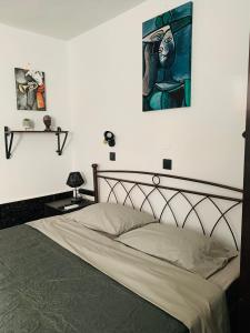 una camera da letto con un letto e un dipinto sul muro di Casa di Angelo a Città di Kos