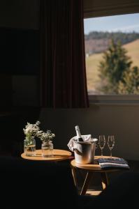 einen Tisch mit zwei Weingläsern und einem Fenster in der Unterkunft Berghotel Wiedener Eck in Wieden