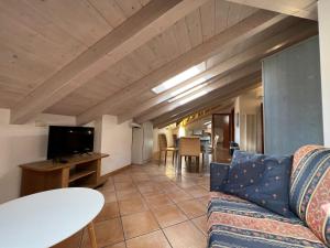 una sala de estar con un sofá y una mesa en Mansarda Baia Azzurra 8, en Nago-Torbole