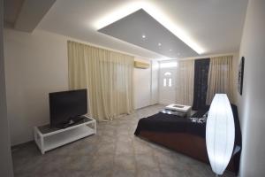 a hotel room with a bed and a television at K&C Rooms- Apartments in Markopoulo