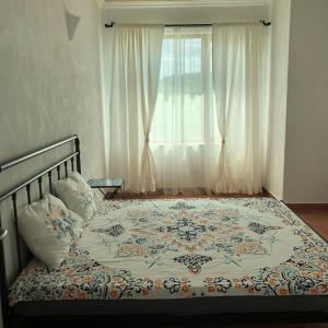 een bed in een slaapkamer met een raam bij Къща за гости “ ОАЗИС “ ет.2 in Lozenets