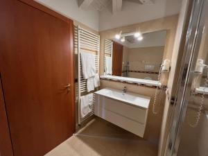un baño con lavabo y espejo en Mansarda Baia Azzurra 8, en Nago-Torbole 28 fotos más