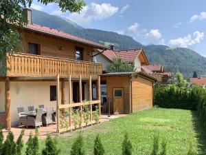 a house with a patio and a yard with chairs at Chalet Giusto in Kötschach