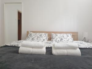 a bed with two pillows on top of it at Novi Apartman 19 in Foča