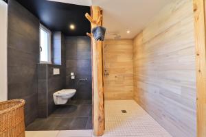 Locations des 3 sommets avec Sauna et Spa en Alsace في Sondernach: حمام مع دش خشبي مع مرحاض