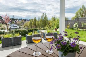twee glazen wijn zittend op een tafel met bloemen bij Turmgarten in Überlingen