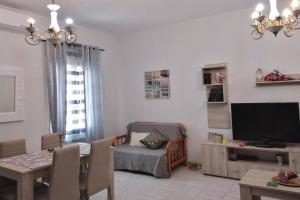 a living room with a dining table and a television at Vion Place Pilos in Pylos
