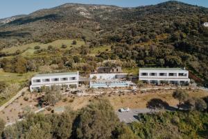 Vue aérienne d'un bâtiment sur une colline dans l'établissement VILLA FLAKA Boutique Hôtel, à Cargèse