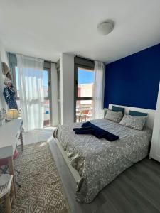 1 dormitorio con 1 cama grande y pared azul en Casa Uma, en Corralejo