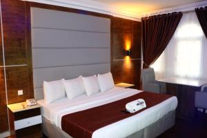 Habitación de hotel con cama grande con almohadas blancas en PRESKEN WHITE HOUSE en Lagos