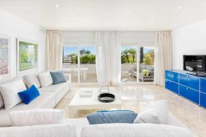 sala de estar con sofá blanco y armarios azules en Marbella Golf y Beach Santa Clara By Houselogy en Marbella