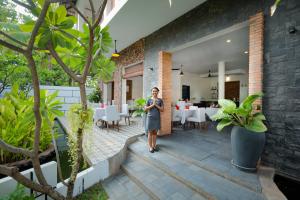 una mujer está parada en el patio de una casa en Bopha Wat Bo Residence en Siem Reap