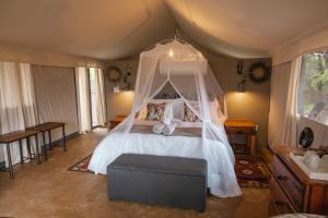 a bedroom with a bed with a canopy at Umkumbe Bush Lodge - Luxury Tented Camp in Skukuza