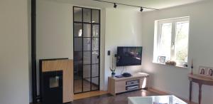 a living room with a tv and a entertainment center at Très belle Villa 4 façades dans quartier vert et arboré - 5 kms de Namur in Namur