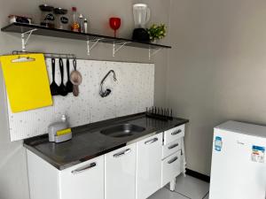 a kitchen with a sink and a white refrigerator at Apartamento INTEIRO próximo ao Aeroporto in Marabá