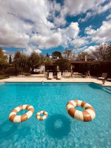 a swimming pool with two inflatables in the water at 4 Saisons en Provence in Saint-Paul-en-Forêt