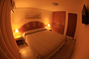 a bedroom with a bed with two lamps on it at Garbos Soleil Hotel in Natal