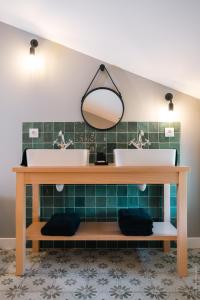 uma casa de banho com 2 lavatórios e um espelho em Entre Chênes et Pins - Gîte de groupe 3 étoiles em Hostens