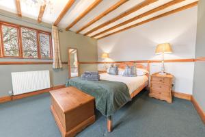 1 dormitorio con cama, mesa y ventanas en Smithy Cottage en Hawkshead