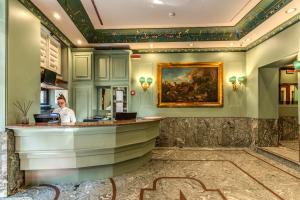 a woman standing at a bar in a hotel lobby at Madison Hotel in Rome