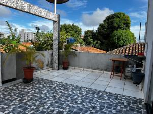 eine Terrasse mit Topfpflanzen und einem Zaun in der Unterkunft Apartamento INTEIRO próximo ao Aeroporto in Marabá