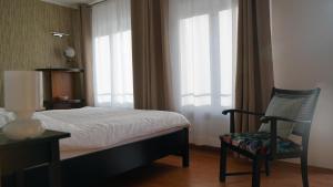 a bedroom with a bed and a chair and window at Ferienwohnung Meine Tante in Trittenheim