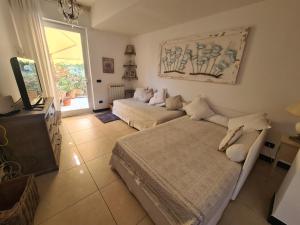 a living room with two beds and a television at Casa di Bianca by PortofinoVacanze in Santa Margherita Ligure