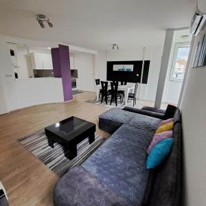 ein Wohnzimmer mit einem Sofa und einem Tisch in der Unterkunft Jove Apartments in Bitola