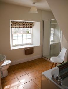 a bathroom with a toilet and a sink and a window at The Clock Tower in Selkirk