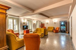 a living room with orange chairs and a tv at Madison Hotel in Rome