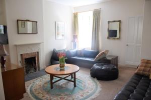 sala de estar con sofá y mesa en The Stables, en Carsethorn