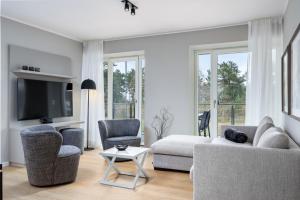 - un salon avec un canapé, des chaises et une télévision dans l'établissement Strandresidenzen Binz-Prora Strandresidenzen Binz-Prora D1 3, à Binz