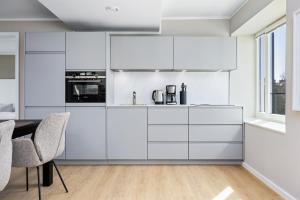 a kitchen with white cabinets and a table and chairs at Strandresidenzen Binz-Prora Strandresidenzen Binz-Prora D5 5 in Binz +12 photos