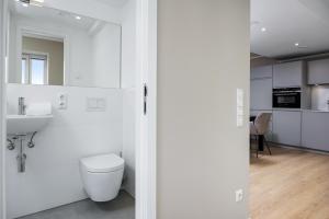 a white bathroom with a toilet and a sink at Strandresidenzen Binz-Prora Strandresidenzen Binz-Prora D5 5 in Binz