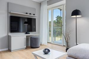 uma sala de estar branca com uma televisão e um sofá em Strandresidenzen Strandresidenzen Haus Dänholm 2 3 em Binz