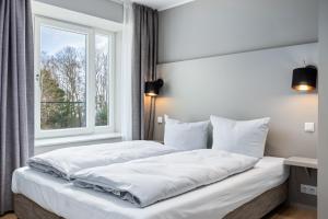 um quarto com 2 camas e uma janela em Strandresidenzen Strandresidenzen Haus Dänholm 2 3 em Binz