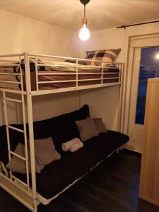 a bedroom with two bunk beds with a couch underneath at Cosy & modern 3 bedroom house close to the beach in Katwijk aan Zee