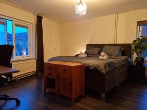 a bedroom with a bed with two stuffed animals on it at Cosy & modern 3 bedroom house close to the beach in Katwijk aan Zee