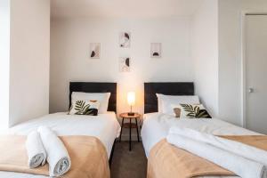2 łóżka pojedyncze w pokoju ze stołem w obiekcie Saffira - 2 bedroom Flat w mieście Bracknell