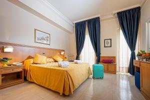 ジャルディーニ・ナクソスにあるHotel Sabbie d'Oroのベッドルーム1室(黄色のベッドカバー付)