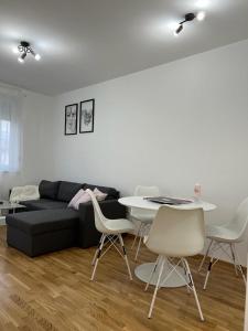 uma sala de estar com um sofá preto e uma mesa e cadeiras em Natalija Stan na dan em Banja Luka