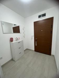 uma casa de banho com uma porta castanha e um armário branco em Natalija Stan na dan em Banja Luka