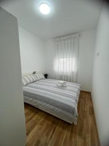 um quarto branco com uma cama e uma janela em Natalija Stan na dan em Banja Luka