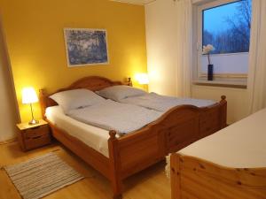 a bedroom with a wooden bed and a window at radlerunterkunft Grabau Nr.1 