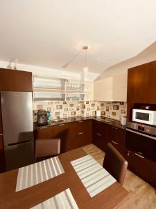 a kitchen with wooden cabinets and a table and a microwave at Silver Mountain C24 Royal in Poiana Brasov